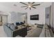 Living room with gray sofas, blue accent chairs, and a geometric textured wall at 4449 Shiva Loop, Kissimmee, FL 34746
