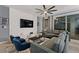 Living room features gray couches and chairs, a coffee table, and a geometric accent wall at 4449 Shiva Loop, Kissimmee, FL 34746