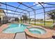 Screened pool and spa with lounge chairs; backyard oasis with lake view at 4449 Shiva Loop, Kissimmee, FL 34746