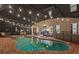 Night view of freeform pool and spa with covered patio and string lights at 4449 Shiva Loop, Kissimmee, FL 34746