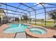Freeform pool and spa with covered patio, string lights and view of lake at 4449 Shiva Loop, Kissimmee, FL 34746