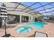 Relaxing freeform pool and spa with brick pavers and covered patio at 4449 Shiva Loop, Kissimmee, FL 34746