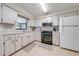 Bright kitchen with white cabinets, black appliances, and ample counter space at 6446 Creation St, Saint Cloud, FL 34771