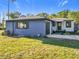 Updated home exterior with a gray-blue color scheme, a garage, and a well-maintained lawn at 905 W 11Th Ave, Mount Dora, FL 32757