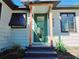 Charming front entrance with a green door, wooden posts, and brick steps at 905 W 11Th Ave, Mount Dora, FL 32757