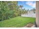 Landscaped backyard with a grassy lawn and a white fence at 1233 Aquila Loop, Celebration, FL 34747