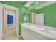 Double vanity bathroom with green walls and a view of a bedroom at 1233 Aquila Loop, Celebration, FL 34747