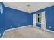 Bright bedroom with blue walls, plush carpeting, and a window with sheer curtains at 1233 Aquila Loop, Celebration, FL 34747