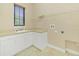 Laundry room with white cabinets, a countertop sink and overhead shelving at 1233 Aquila Loop, Celebration, FL 34747
