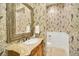 Powder room with decorative wallpaper and ornate vanity at 1233 Aquila Loop, Celebration, FL 34747