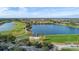 Aerial view of a community with houses, golf course, and lake at 1287 Glendora Rd, Kissimmee, FL 34759