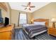King-size bed, wood dresser, and TV in a well-lit bedroom with laminate flooring at 2302 Butterfly Palm Way # 303, Kissimmee, FL 34747