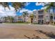 Exterior of apartment building showcasing landscaping and parking at 2302 Butterfly Palm Way # 303, Kissimmee, FL 34747