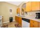 Galley kitchen with wood cabinets, white appliances, and tile floors at 2302 Butterfly Palm Way # 303, Kissimmee, FL 34747