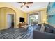 Living room with gray sofa, beach mural, and access to a balcony at 2302 Butterfly Palm Way # 303, Kissimmee, FL 34747