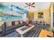 Living area with gray sofa and beach-themed wall mural at 2302 Butterfly Palm Way # 303, Kissimmee, FL 34747