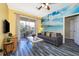 Living room with gray sofa, beach mural, and access to a balcony at 2302 Butterfly Palm Way # 303, Kissimmee, FL 34747