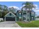 Two-story house with dark green exterior, attached garage, and palm trees at 2350 Chadwick Cir, Kissimmee, FL 34746