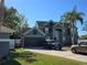 Two-story house with a green exterior, two-car garage, and palm trees at 2350 Chadwick Cir, Kissimmee, FL 34746