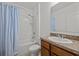Bathroom with tub shower, wood vanity and blue striped curtain at 355 Highcrest Rd, Davenport, FL 33896