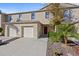 Tan two-story townhome with two-car garage and landscaping at 355 Highcrest Rd, Davenport, FL 33896