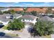 Aerial view of homes with gray and orange roofs, paved roads, and lush green landscaping at 4603 Cumbrian Lakes Dr, Kissimmee, FL 34746