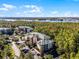 Aerial view of residential building near a lake, showcasing ample parking and lush greenery at 9051 Treasure Trove Ln # 207, Kissimmee, FL 34747