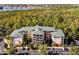 Aerial view of a multi-unit residential building with parking and surrounding trees at 9051 Treasure Trove Ln # 207, Kissimmee, FL 34747