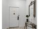Condo entryway with white door, glass-top table, and mirror at 9051 Treasure Trove Ln # 207, Kissimmee, FL 34747