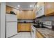White appliances and wood cabinets in this well-equipped kitchen at 9051 Treasure Trove Ln # 207, Kissimmee, FL 34747