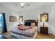 King-size bed, wood furniture, and access to the balcony in this main bedroom at 9051 Treasure Trove Ln # 207, Kissimmee, FL 34747