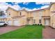 Front view of two story townhouse, two car garage, and landscaped lawn at 1355 Pacific Rd, Kissimmee, FL 34759