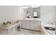 Bathroom with double vanity, a large mirror, and a soaking tub at 1880 Goblet Cove St, Kissimmee, FL 34746