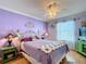 Charming bedroom with lavender walls, a queen bed, and decorative accents at 2494 Five Forks Trl, The Villages, FL 32162