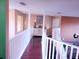 Upstairs hallway with hardwood floors and white railings at 2606 Royal Fern Pl, Kissimmee, FL 34758