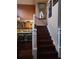 Staircase with wood railing and view of kitchen at 2606 Royal Fern Pl, Kissimmee, FL 34758