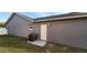 Rear view of house showing AC unit and exterior door to storage area at 552 Brentford Ct, Kissimmee, FL 34758