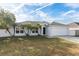 One-story house with a white exterior, gray roof, and a two-car garage at 557 Dove Ct, Kissimmee, FL 34759