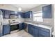 Modern kitchen with blue cabinets and granite countertops at 557 Dove Ct, Kissimmee, FL 34759