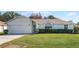 House exterior featuring a single-story home with attached garage and well-maintained lawn at 607 Tamarin Ln, Kissimmee, FL 34759