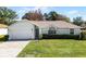 Single-story home with a two-car garage and neat landscaping at 607 Tamarin Ln, Kissimmee, FL 34759