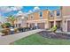 Tan three-story townhouses with brown garages and a paved driveway at 1336 Chelsea Dr, Davenport, FL 33897