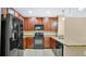 Modern kitchen with dark wood cabinets, granite counters, and black appliances at 1336 Chelsea Dr, Davenport, FL 33897
