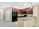 Modern kitchen with dark wood cabinets, granite counters, and black appliances at 1336 Chelsea Dr, Davenport, FL 33897