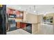 Modern kitchen with dark wood cabinets, granite counters, and black appliances at 1336 Chelsea Dr, Davenport, FL 33897