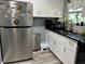 Stainless steel refrigerator and white kitchen cabinets at 1615 Jefferson Dr, Mount Dora, FL 32757