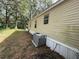 Side view of mobile home and AC unit at 4914 Dove Ln, Auburndale, FL 33823