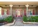 Inviting front porch with rocking chair and red door at 759 Glendora Rd, Poinciana, FL 34759