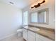 Clean bathroom with granite countertop, white cabinets, and updated fixtures at 865 Scenic View Cir, Minneola, FL 34715