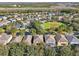 Aerial view of community, showing homes, landscaping, and a large green space with a basketball court at 9026 Dry Creek Ln, Orlando, FL 32832